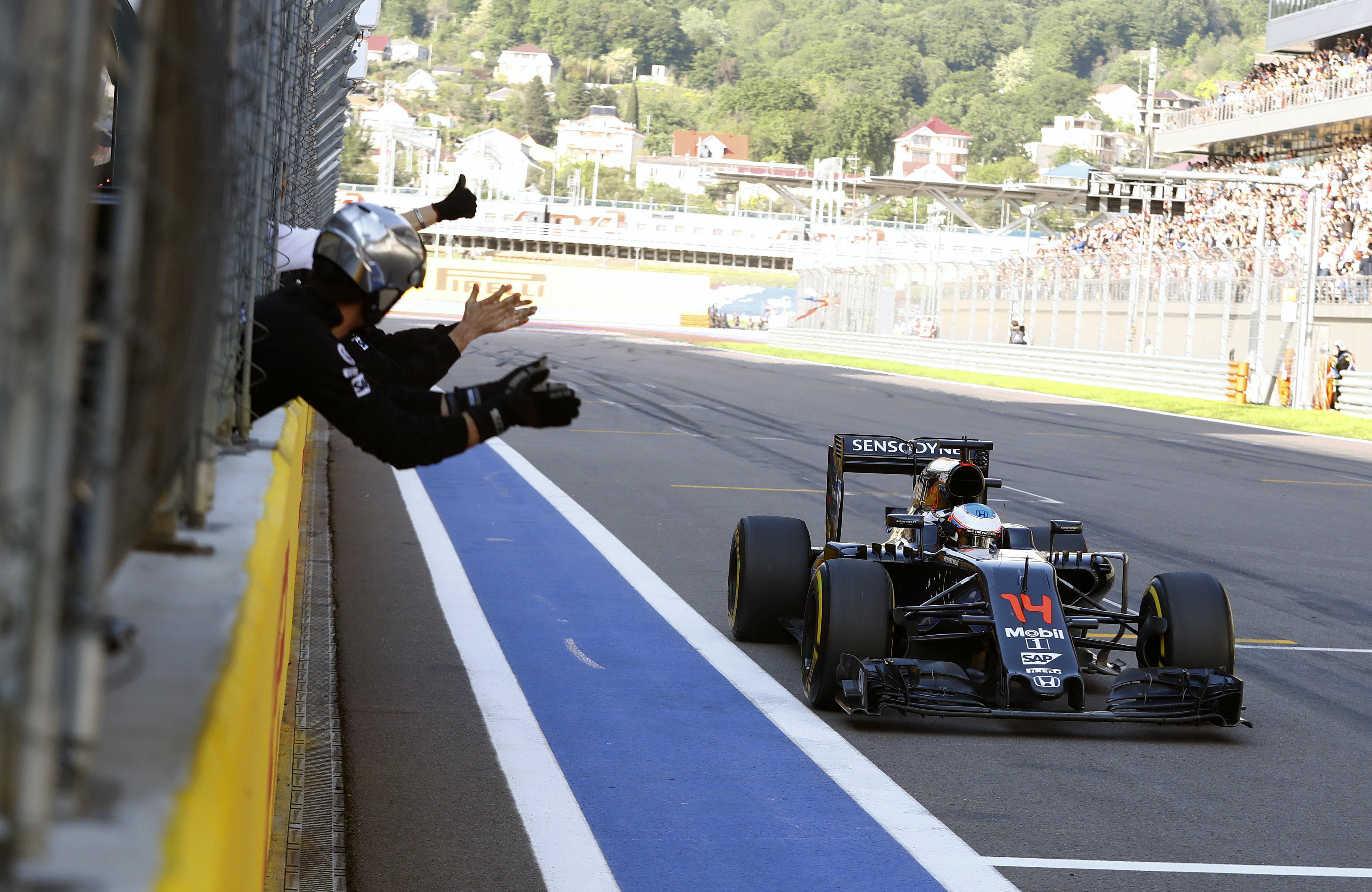 Team members congratulate Fernando Alonso on his sixth place finish.